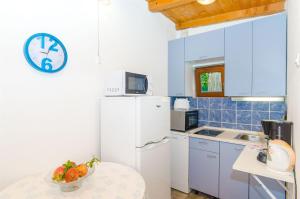 uma cozinha com um frigorífico e um relógio na parede em House Mislav II em Velike Kuknjare
