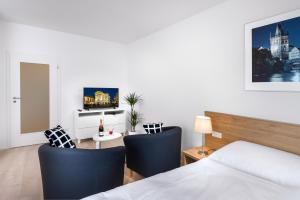 a bedroom with a bed and a desk with chairs at CityWest Apartments in Prague