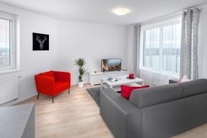 a living room with a couch and a red chair at CityWest Apartments in Prague