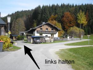 Camino de aphalt con una casa con una flecha apuntando a una casa con enlaces en Ferienwohnung Ötscherwiese, en Lackenhof