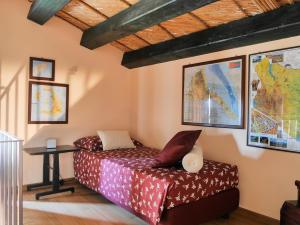 a bedroom with a bed and a table and a map at La Casetta Sicilian Cottage in Case Rosolia +39 photos