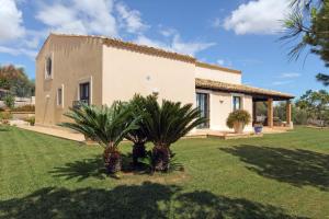 a house with palm trees in front of it at La Casetta Sicilian Cottage in Case Rosolia