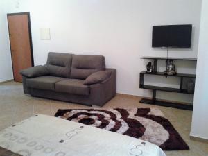 sala de estar con sofá y TV en Casa Neuza, en Fuseta