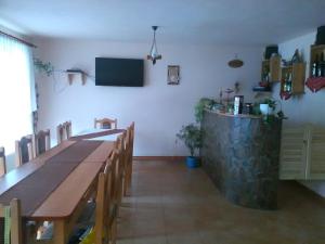 a dining room with a long table and a television at Casa cu Muscate in Cîmpeni