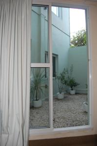 una puerta corredera de cristal con macetas delante de un edificio en Horizonte Hotel, en Mar del Plata