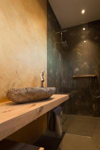 a bathroom with a stone sink on a wooden counter at das Ferienhaus Auszeit in Kranenburg