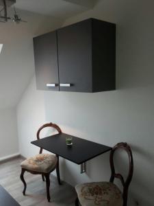 a black table with two chairs and a black cabinet at Apartment Central in Erfurt +1 photo