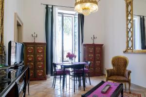 a living room with a table and chairs and a chandelier at Maria Vittoria Charming Rooms and Apartments in Brindisi