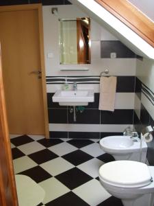 ein Bad mit schwarz-weiß kariertem Boden in der Unterkunft Anonim apartman in Villány