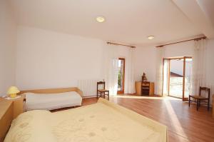 a white room with a bed and a table at House Marija in Fažana