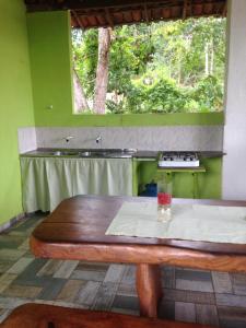 una mesa de madera en una cocina con ventana en Sítio FWG en Camaçari