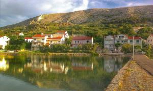 a group of houses next to a body of water at Apartmani Rija 3 in Pag