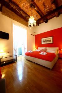 una camera con un grande letto con una parete rossa di Talismano Luxury Rooms & Apartments a Napoli