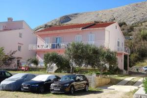 a couple of cars parked in front of a house at Apartmani Rija 3 in Pag +14 photos
