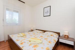 Un dormitorio con una cama con toallas amarillas. en Apartments Miljenko, en Punat