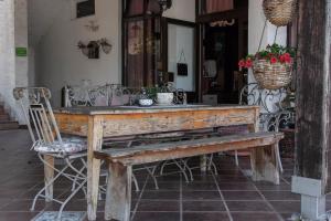 a wooden table with a bench and flowers on it at Pansion Ruzic in Međugorje