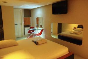 um quarto com 2 camas, uma mesa e uma cozinha em Rhodes Hotel Recife no Recife