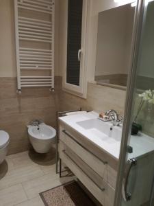 een badkamer met een wastafel, een toilet en een douche bij La casa di Anna in Viareggio