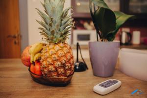 a bowl of fruit on a table with a remote control at Brilliant Apartman in Bihać