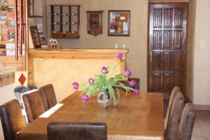 une table en bois avec un vase de fleurs violettes dans l'établissement Le Pèlerin, à Montségur