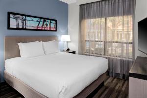 um quarto com uma grande cama branca e uma janela em Hyatt House Dallas Lincoln Park em Dallas