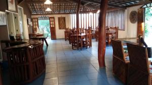 une salle à manger avec des tables et des chaises en bois dans l'établissement Pousada Brisa do Mar, à Barra Grande