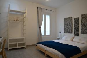 a white bedroom with a bed and a window at Le stanze di LaVi in Ferrara