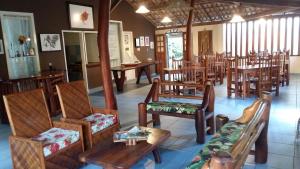 une pièce remplie de chaises et de tables en bois et d'un chercheur de table dans l'établissement Pousada Brisa do Mar, à Barra Grande