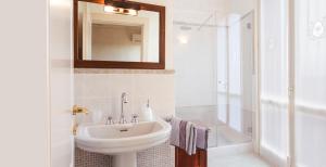een witte badkamer met een wastafel en een douche bij B&B Residence il Ciliegio , Via Villa Superiore 93 Luzzara in Luzzara