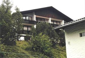 a building on a hill with trees in front of it at Wohnung Alpencottage in Bad Aussee