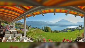 a patio with a view of a lake and mountains at Hotel Restaurant Panorama in Aeschlen