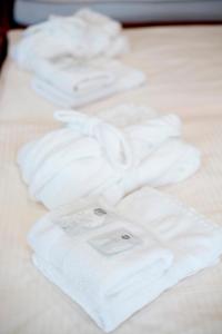 a group of white towels on a bed at Hotel Bristol in Banská Štiavnica