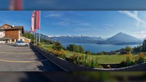 a car parked on the side of a road next to a lake at Hotel Restaurant Panorama in Aeschlen