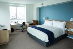 a hotel room with a large bed and a desk at The Study at University City, Study Hotels in Philadelphia