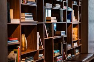 a book shelf filled with lots of books at The Study at University City, Study Hotels in Philadelphia