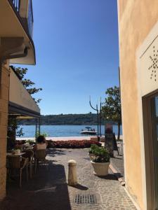 een patio met een tafel en stoelen en uitzicht op het water bij Appartamenti al Golfo in Salò