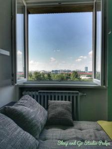 a bed with pillows in front of a large window at Sleep and Go Pedja in Belgrade