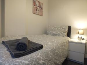 Un dormitorio con una cama con una manta encima. en Walthall Place by SG Property Group, en Crewe