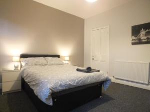 Un dormitorio con una cama con dos lámparas encima. en Walthall Place by SG Property Group, en Crewe 2 fotos más