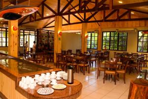 un restaurant avec des tables et des chaises en bois ainsi que des fenêtres dans l'établissement Rio Quente Resorts - Eco Chalés, à Rio Quente