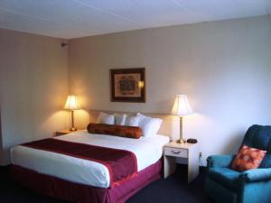 a hotel room with a bed and a chair at Hotel Pigeon Forge in Pigeon Forge
