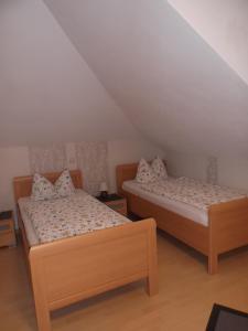 two twin beds in a room with a attic at Zimmer Schmitz in Anschau