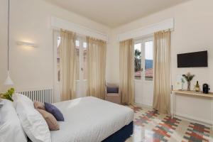 ラ・スペツィアにあるSan Giorgio Boutique Roomsの白いベッドルーム(ベッド1台、窓付)