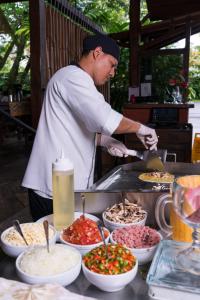 
a man preparing food in a kitchen at Casa Luna Hotel & Spa in Fortuna
