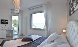 a white bedroom with a bed and a large window at Bellariva Monopoli B&B e Relax in Monopoli