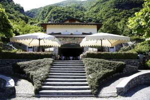 una rampa di scale che conduce a un edificio alberato di Residence Antico Crotto a Porlezza