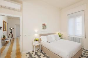 a white bedroom with a bed and a window at San Giorgio Boutique Rooms in La Spezia