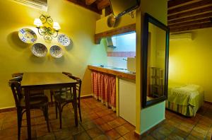 a kitchen and dining room with a table and chairs at Alojamientos Turísticos Rurales La Barataria in Titulcia