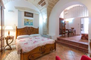 a bedroom with a large bed and a dining room at Corte dei Memoli in Lecce