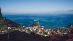 a town on a hill next to the ocean at Hotel Vila Bela in Porto da Cruz